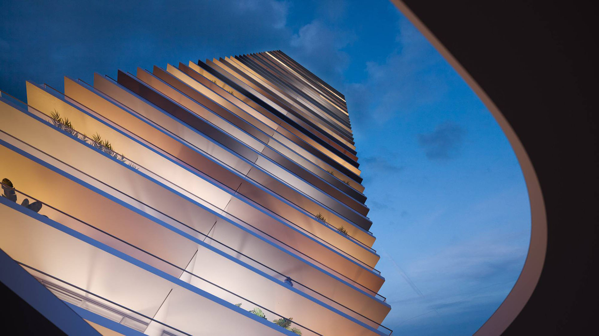 Night architectural view looking up at 2000 Ocean, Hallandale Beach, Florida, with illuminated stacked balconies and curved entry canopy, showcasing luxury and ultra luxury preconstruction condos.