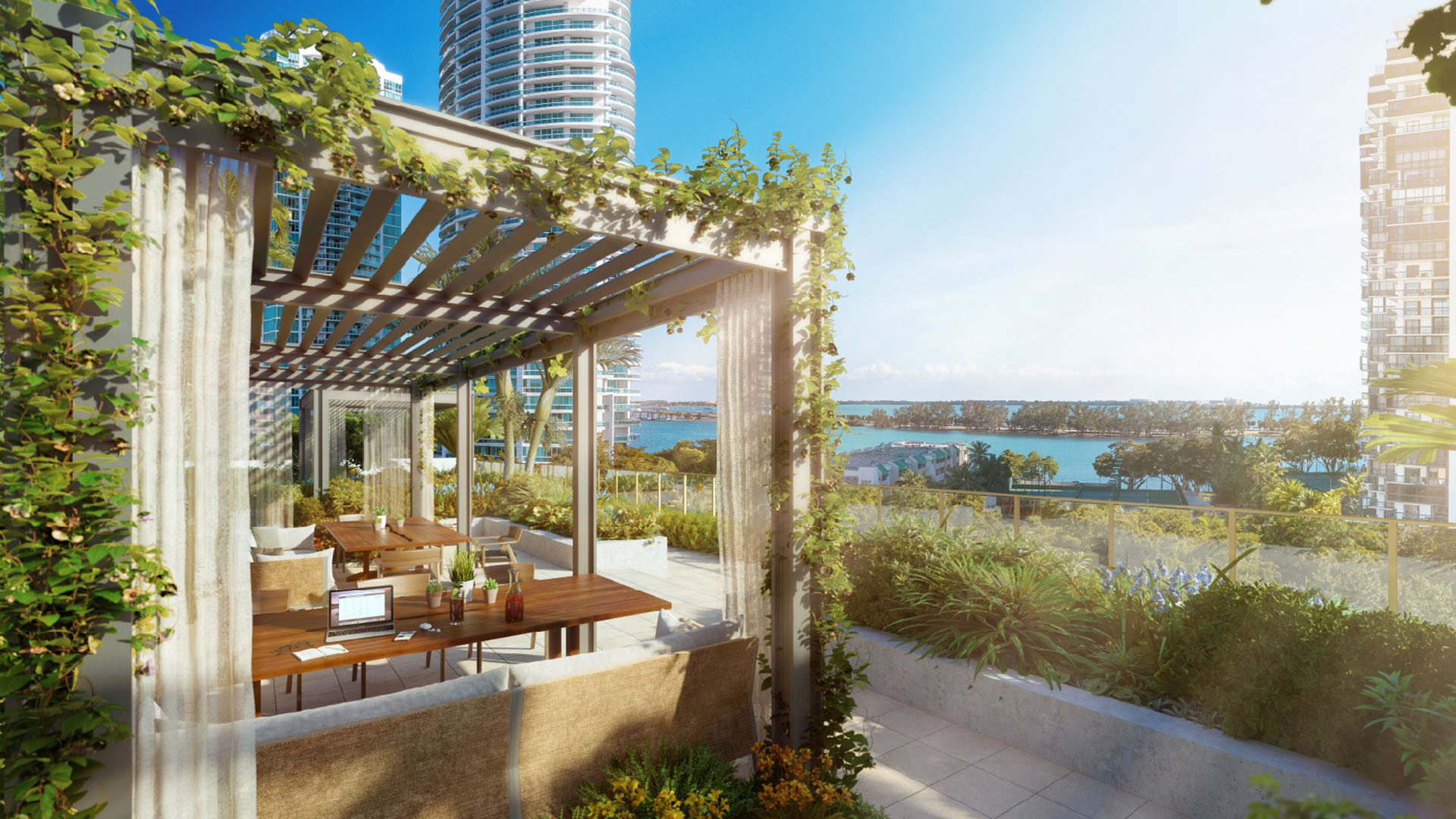 2200 Brickell rooftop lounge with vine-covered pergola, coworking tables and waterfront bay views in Brickell, Miami, featuring luxury and ultra luxury preconstruction condos outdoor amenity terrace.