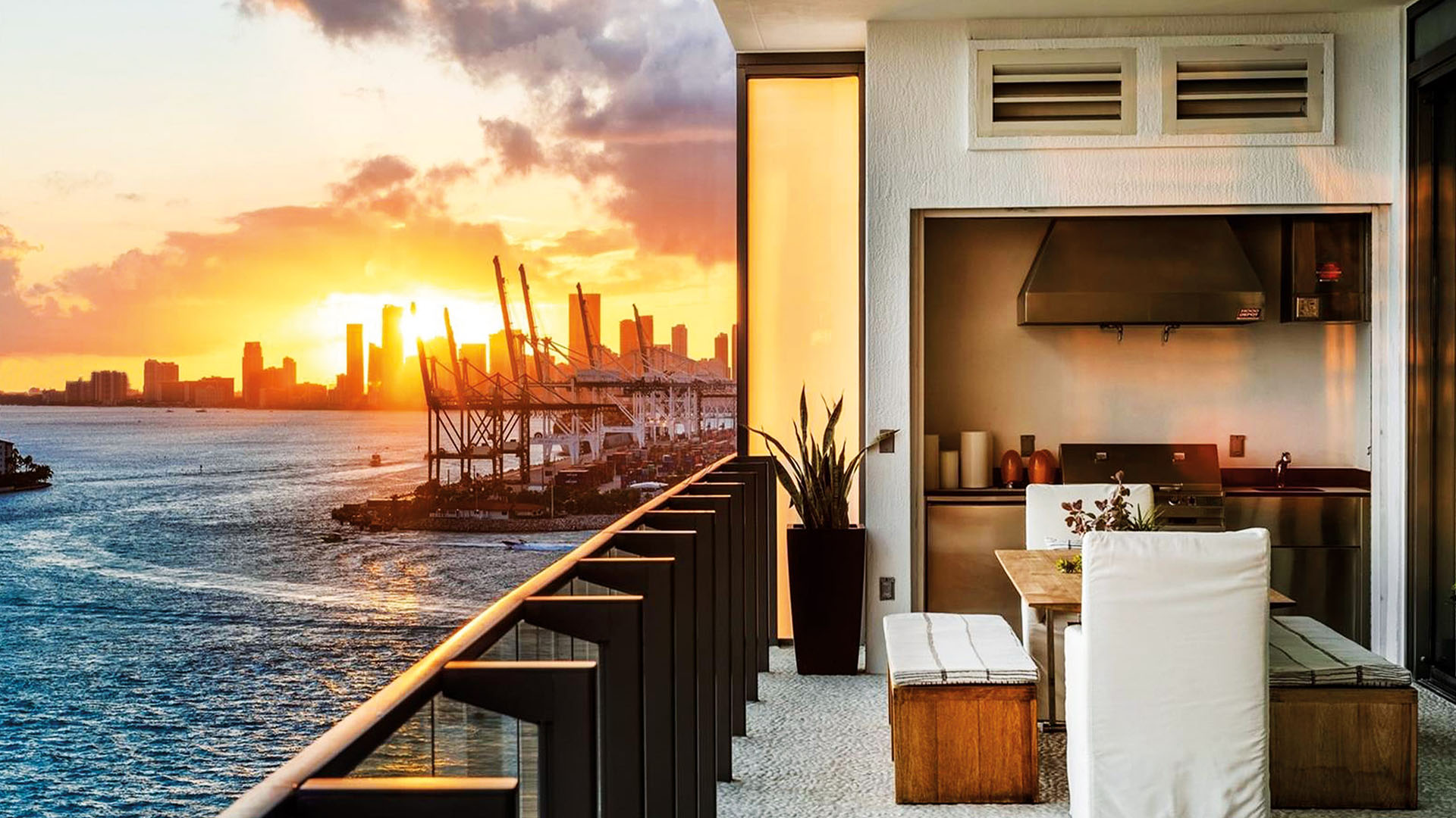 Sunset terrace with an outdoor kitchen, dining nook and skyline views at Apogee in South Beach, reflecting luxury and ultra luxury condos with dramatic waterfront sunsets.