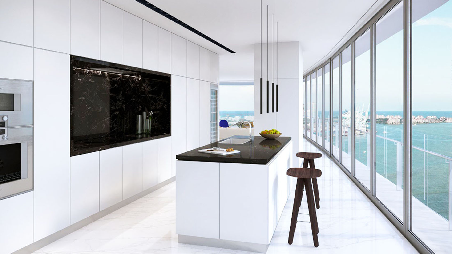 Aston Martin Residences in Downtown Miami luxury and ultra luxury condos gallery kitchen with a black island, curved window wall, and bay views beyond the balcony.