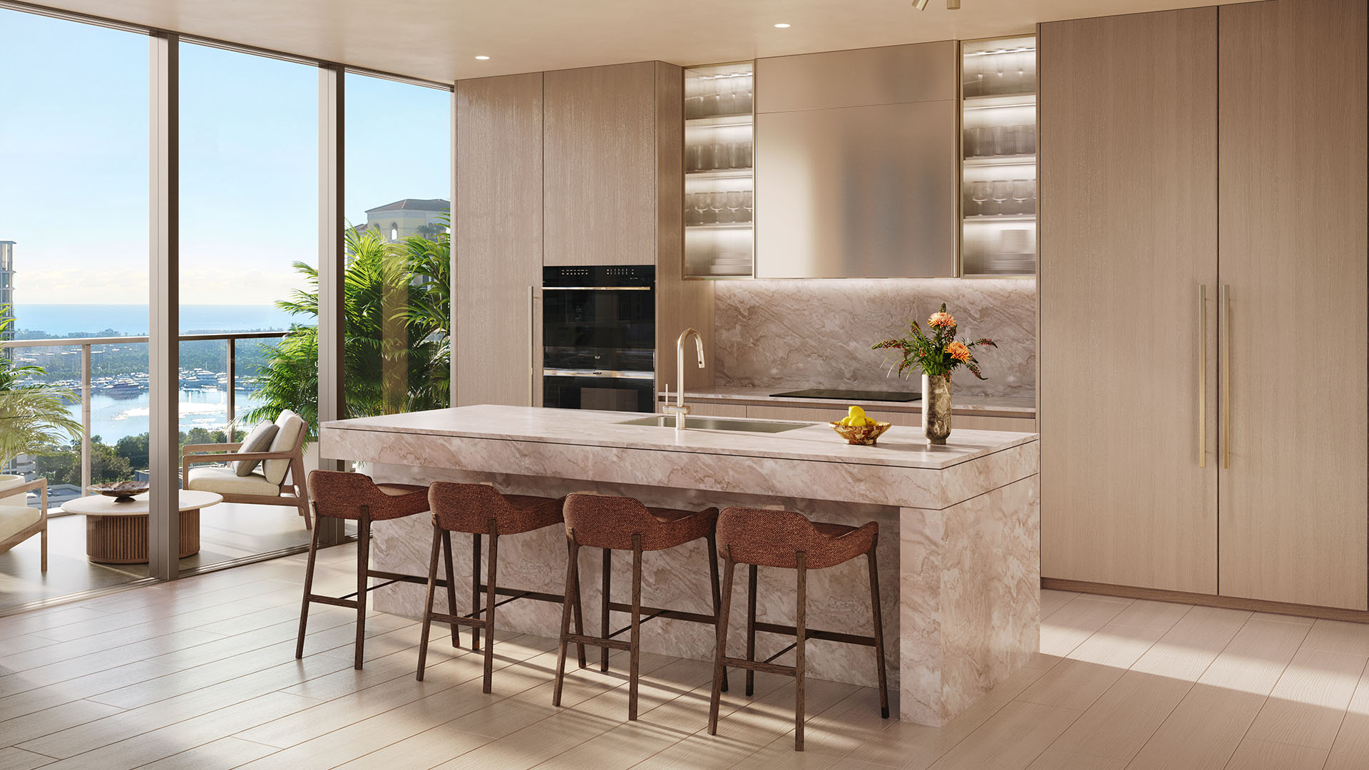 Chef kitchen with a large stone island, bar seating, and full-height windows framing the water at Banyan Tree Residences in West Palm Beach, showing luxury and ultra luxury condos with bright open-plan interiors.