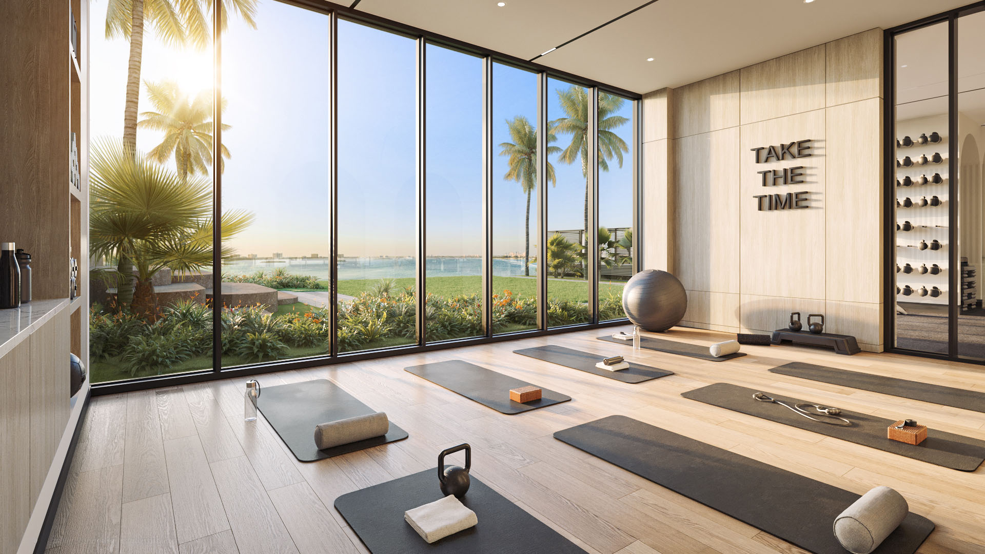Yoga studio with mats, floor-to-ceiling glass, and garden views at Continuum Club and Residences in North Bay Village, a preconstruction luxury and ultra luxury condos development with serene waterfront wellness amenities.