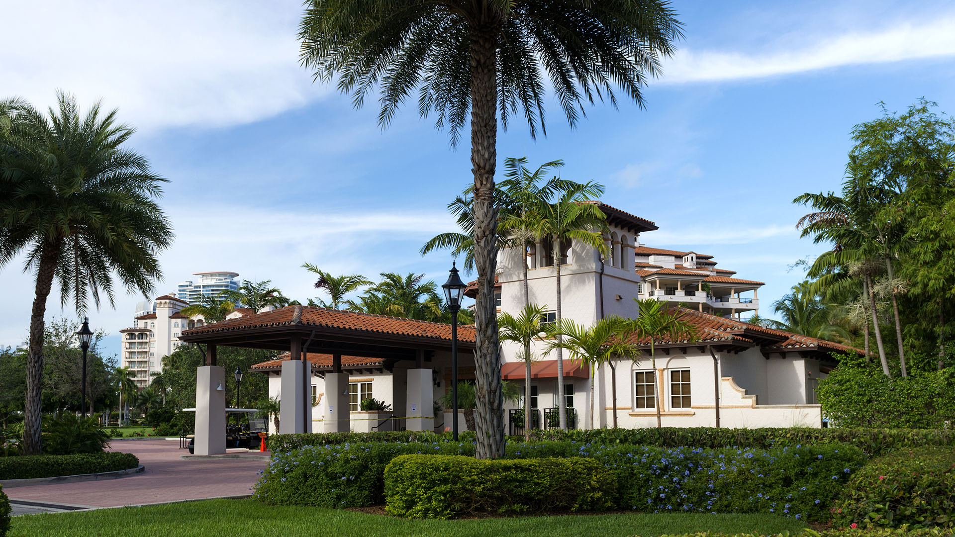 Fisher Island luxury and ultra luxury condos family amenity with a school entrance, palm courtyard, and Mediterranean style buildings.
