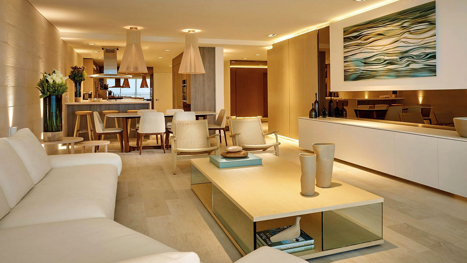 Open-plan living and dining room at Oceana Key Biscayne in Key Biscayne, presenting luxury and ultra luxury condos with warm lighting, modern furnishings, dining space, and a connected kitchen.