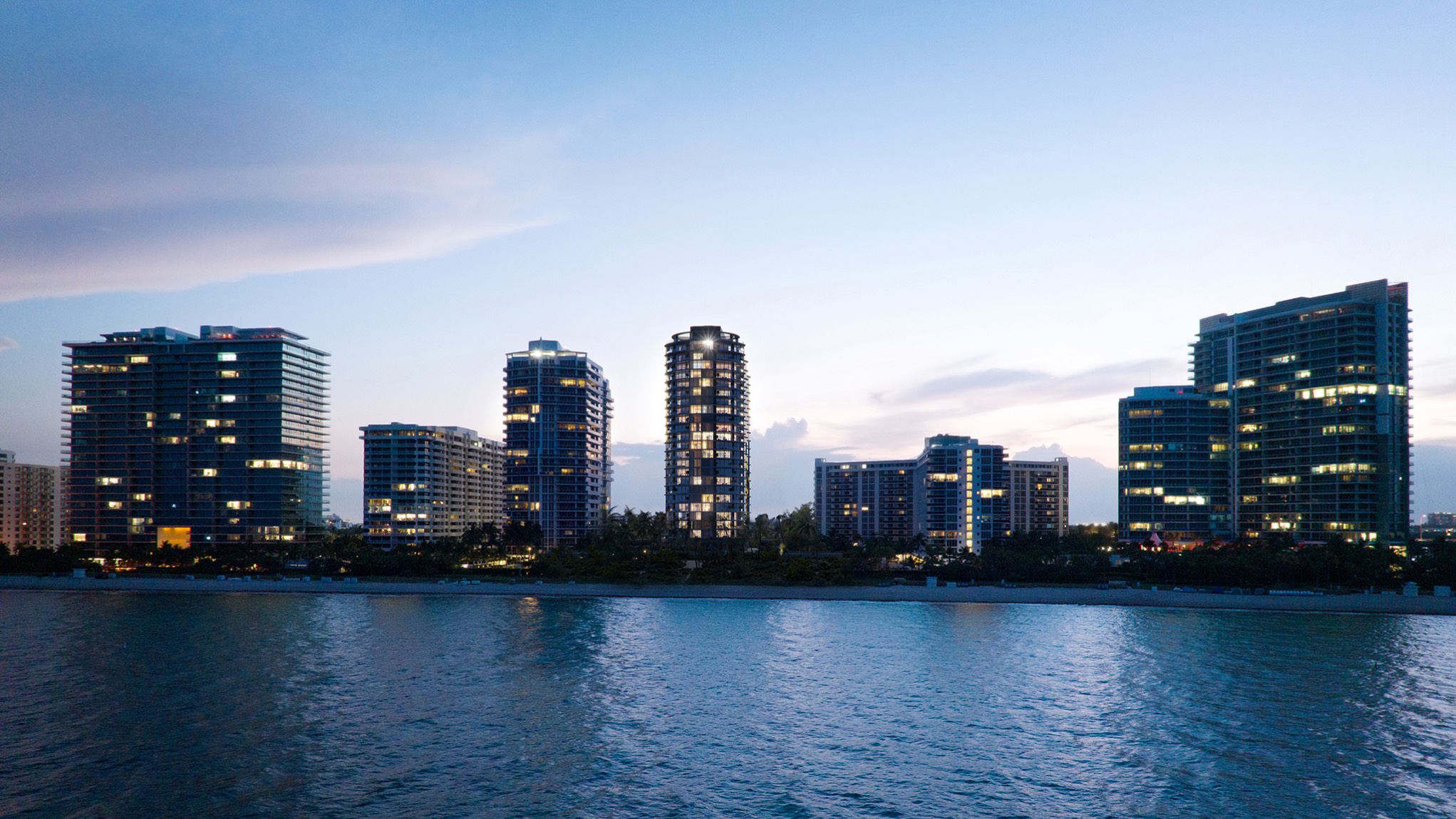 Rivage Bal Harbour, Bal Harbour Miami evening skyline reflected on the water, oceanfront tower setting for luxury and ultra luxury condos; preconstruction. Featuring city and reflection.