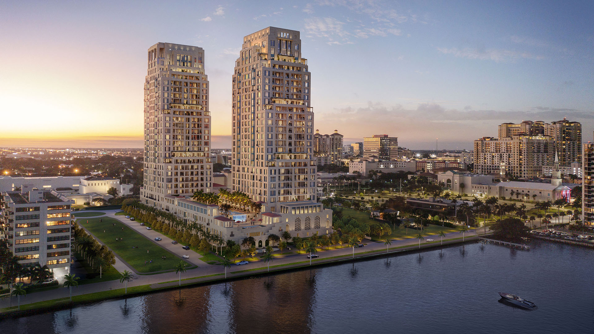 Twilight aerial view of the twin waterfront towers at South Flagler House in West Palm Beach, highlighting luxury and ultra luxury condos with illuminated architecture along the shoreline.