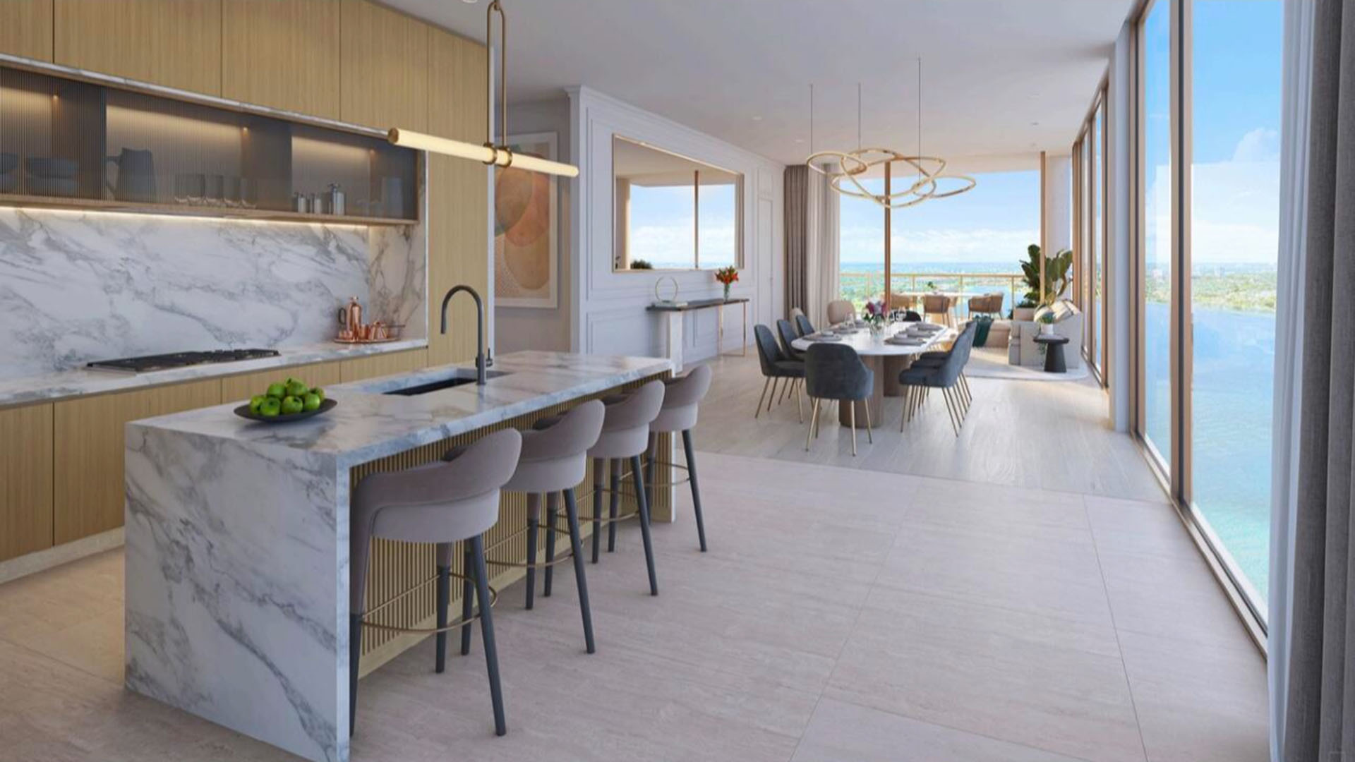 Open chef kitchen with a waterfall marble island, dining area, and water views at The Berkeley in West Palm Beach, showcasing luxury and ultra luxury condos with seamless entertaining space.