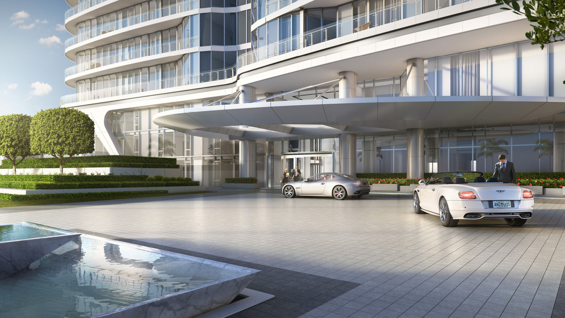 Curved condo exterior with a covered arrival drive and porte cochere entrance at The Bristol Palm Beach in Palm Beach, presenting the luxury and ultra luxury condos arrival experience.