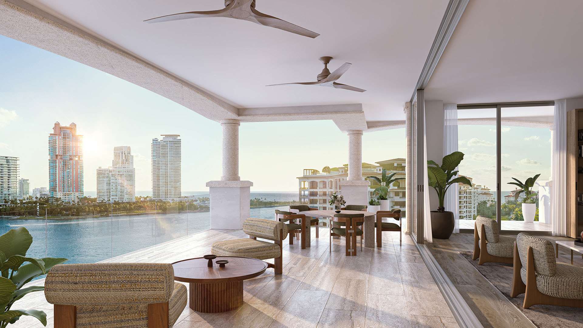 Residence 01 covered balcony dining at The Residences at Six Fisher Island, Fisher Island Miami Beach Florida, ceiling fans and sunset waterfront view; luxury and ultra luxury preconstruction condos with expansive terraces.