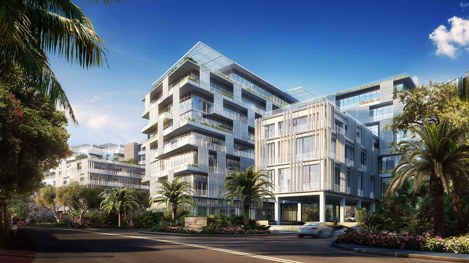 Palm-lined corner exterior entrance at The Ritz-Carlton Residences Miami Beach in Miami Beach, showing luxury and ultra luxury condos with layered glass balconies and lush landscaping.