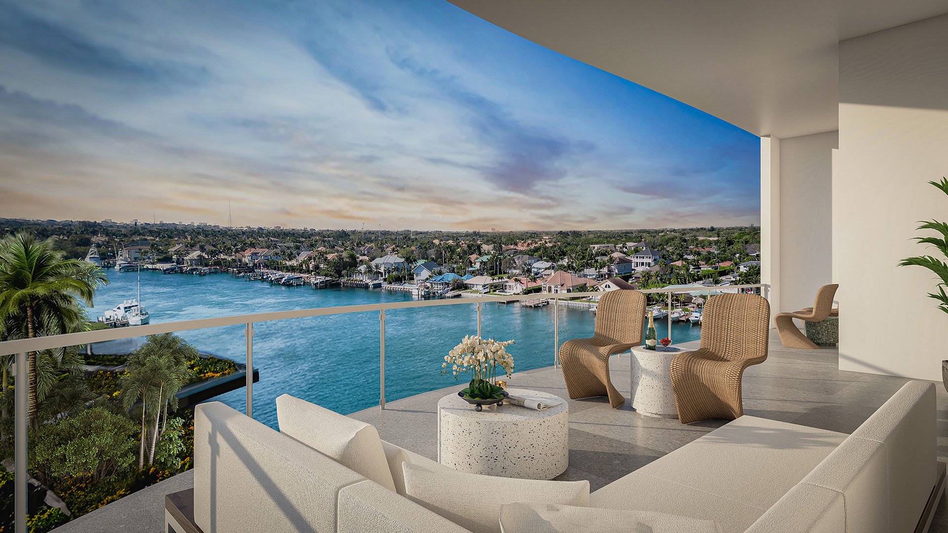 Residence F north building balcony with white sectional, woven lounge chairs and expansive Intracoastal Waterway view at The Ritz-Carlton Residences, Palm Beach Gardens, Florida, showcasing luxury and ultra luxury preconstruction condos.