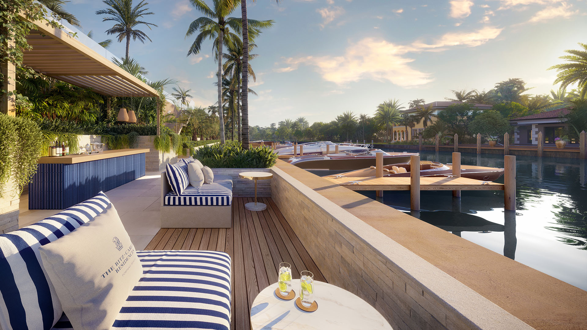 Sundowners outdoor bar lounge at The Ritz-Carlton Residences Pompano Beach Marina Tower with striped seating, sunset cocktails, private dock and yachts on the marina canal, showcasing luxury and ultra luxury preconstruction waterfront condos in Pompano Beach, Florida.