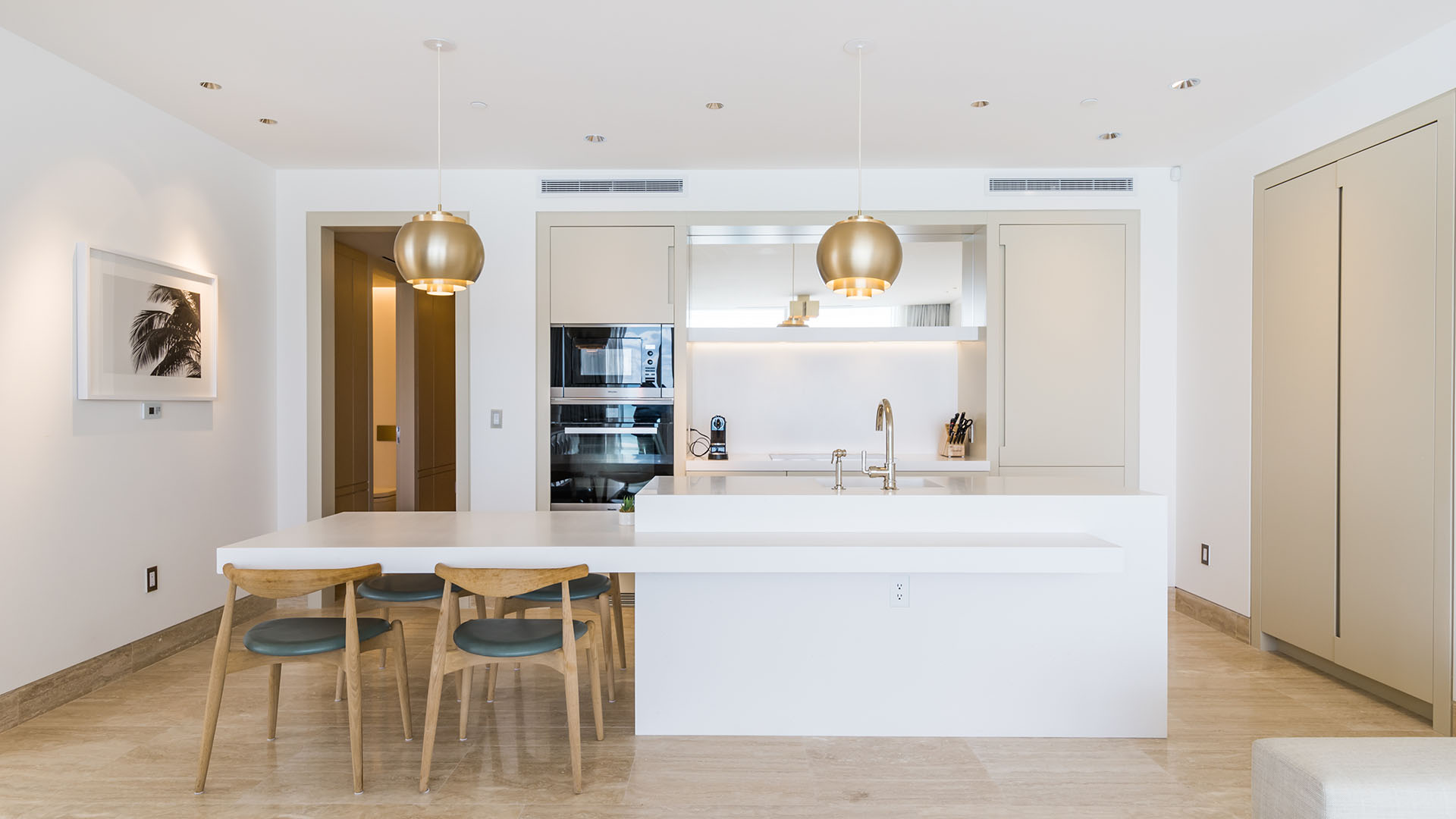 Front-facing chef kitchen with island breakfast bar, pendant lighting, and integrated appliances at The Surf Club Four Seasons, Fort Lauderdale luxury and ultra luxury condos.