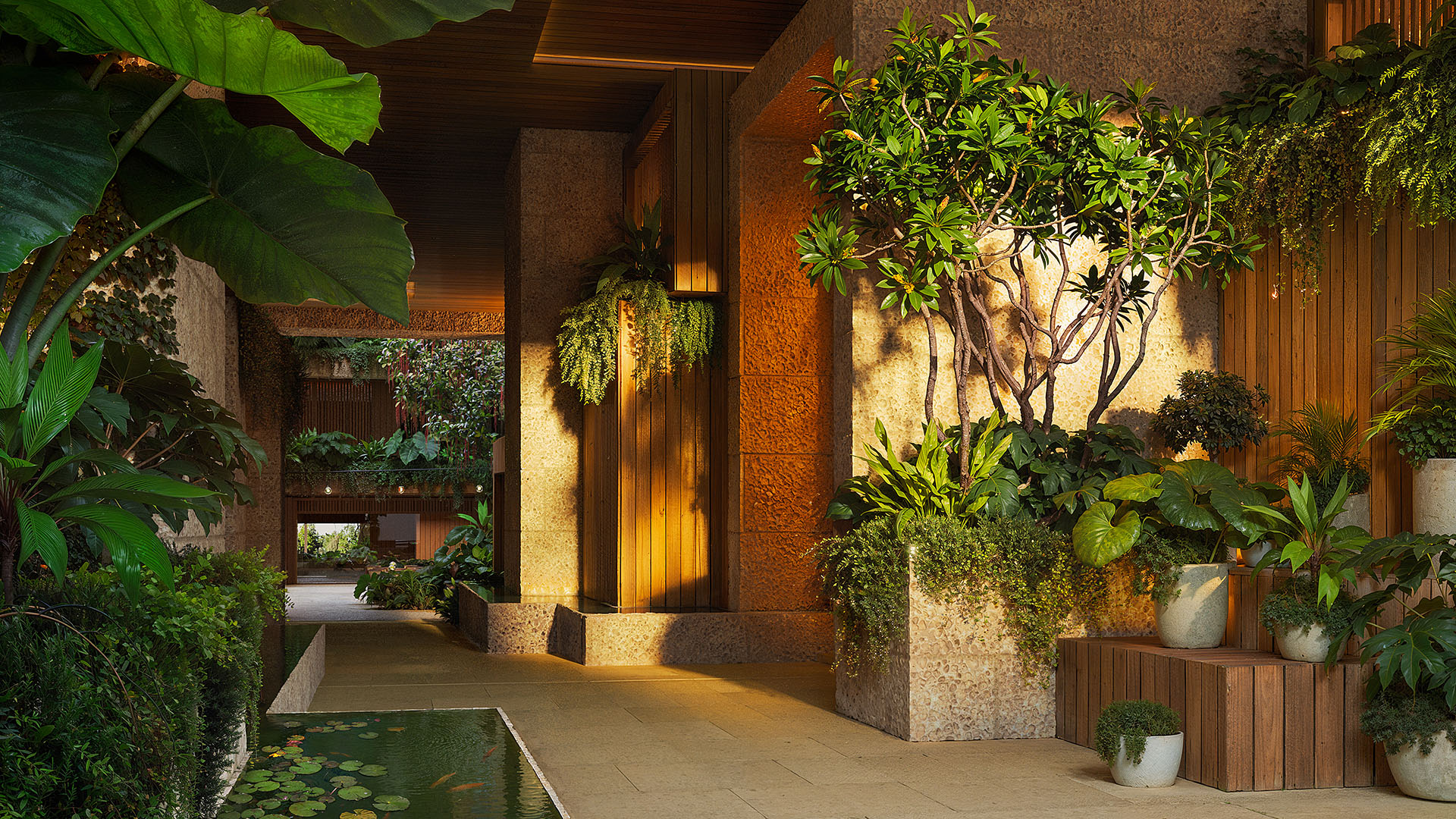 Lush lobby garden entry at Ziggurat Coconut Grove, Miami, Florida, featuring a lily-pond water feature, stone and wood finishes, and tropical plants, setting the tone for luxury living and ultra luxury preconstruction condos.